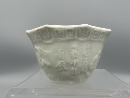 白釉模印庭院人物八方茶盏